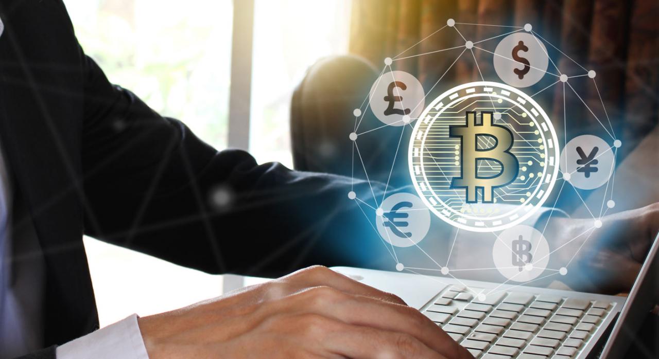 Empresario pagando en bitcoin, usando portátil con pantalla virtual